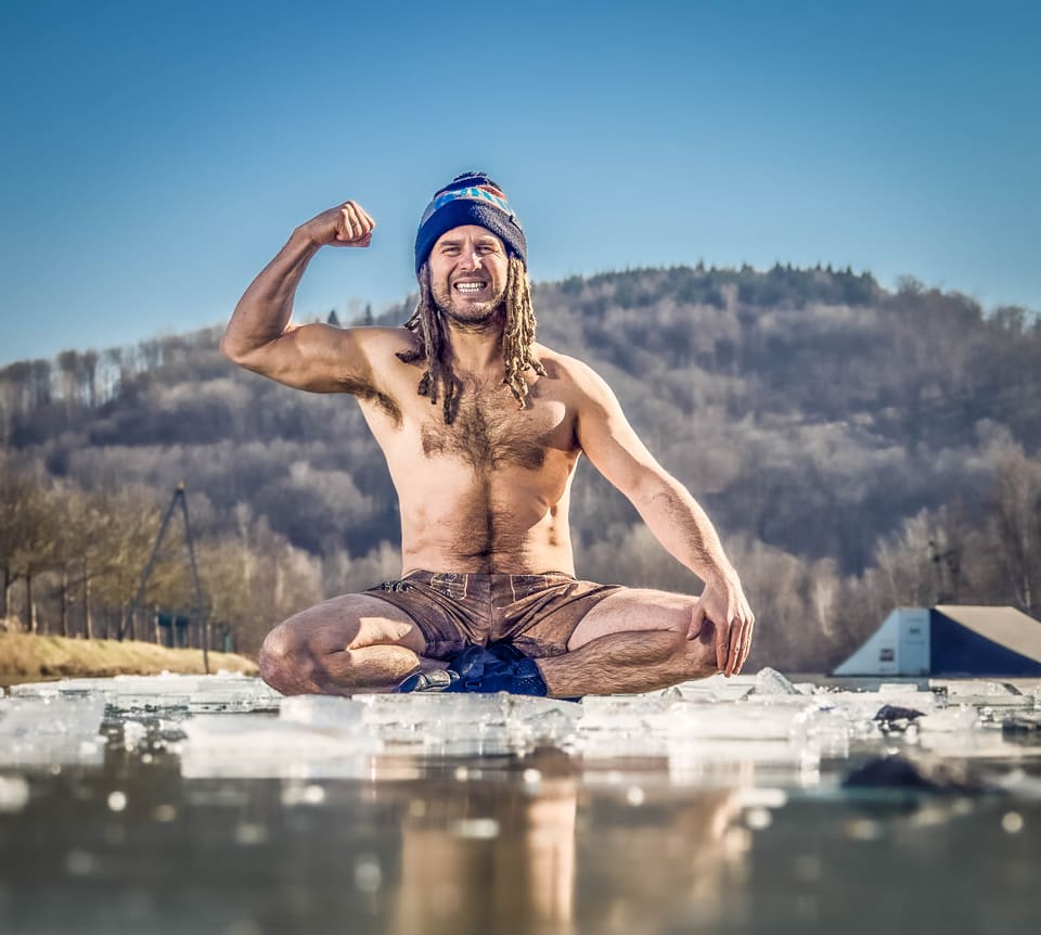Daniel Fetzy Fetz sitzt auf dem Eis und spannt lächelnd den Arm an