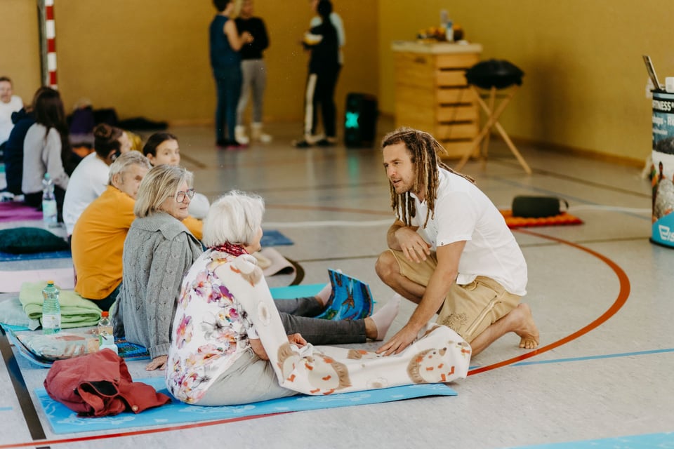 Daniel Fetz spricht mit Teilnehmenden eines Atemfitness Workshops