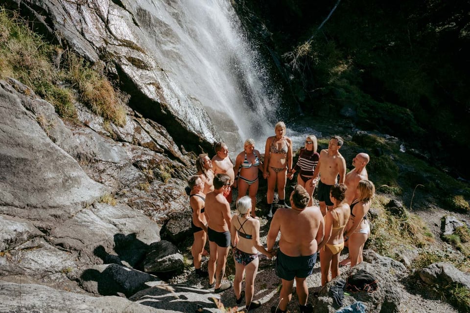 Retreatgruppe versammelt sich im Kreis neben einem Wasserfall im Pitztal